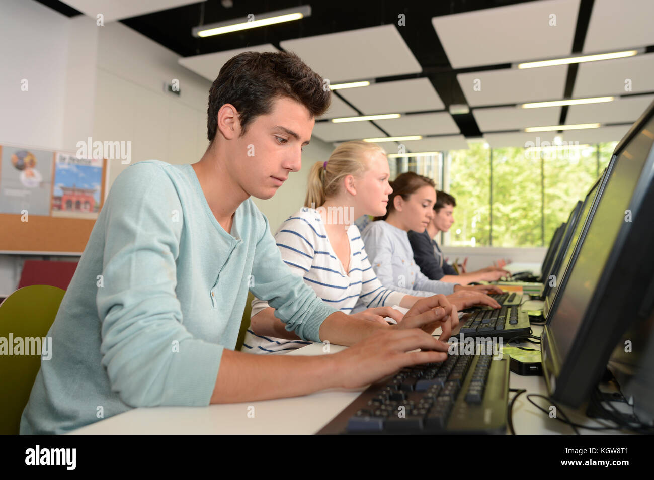 Ragazzo scuola nel calcolo della classe utilizzando il computer Foto Stock