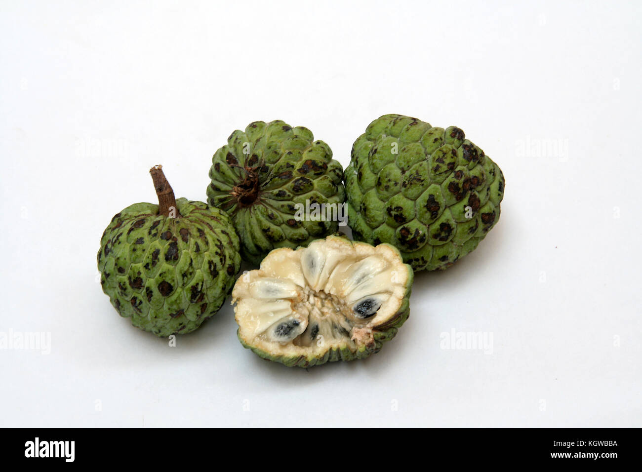 Verde, squamosa crema pasticcera-apple frutti con lunghi, nero semi coperto con dolci, polpa bianca Foto Stock