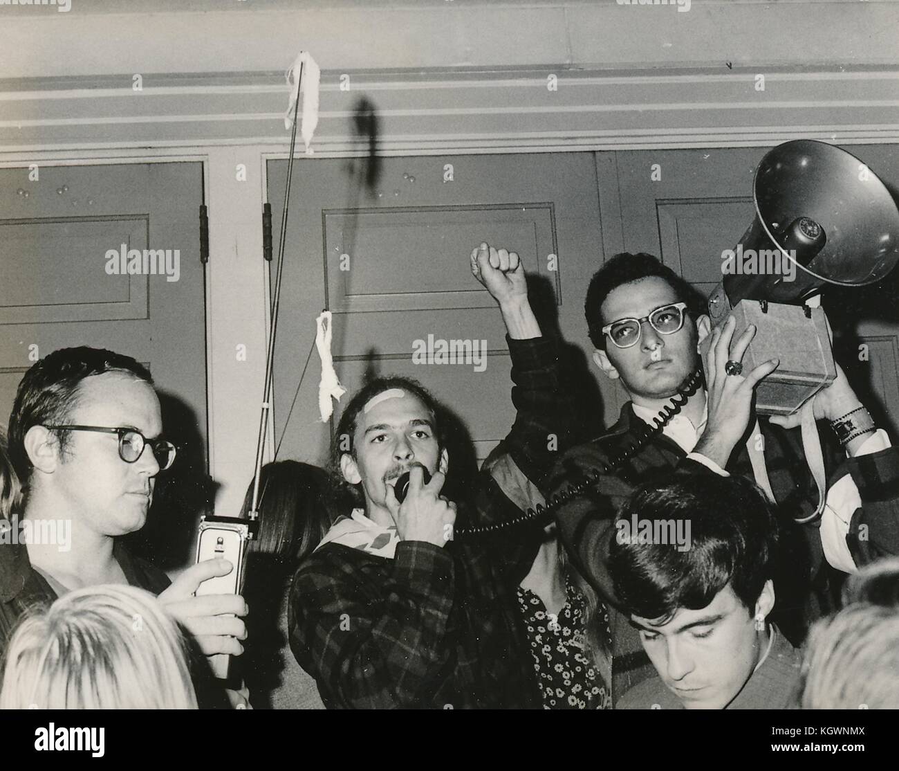 Studente che indossa un abbigliamento hippie tenendo il pugno in aria e parlando nel microfono di un altoparlante del corno durante una protesta contro il Vietnam degli studenti del sit-in alla North Carolina State University, Raleigh, North Carolina, 1970. () Foto Stock