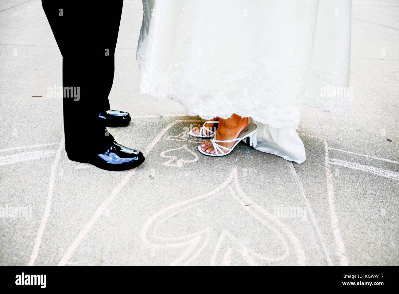 Corpi inferiori vista della sposa e lo sposo in piedi su un chalk cuore disegno su strada Foto Stock
