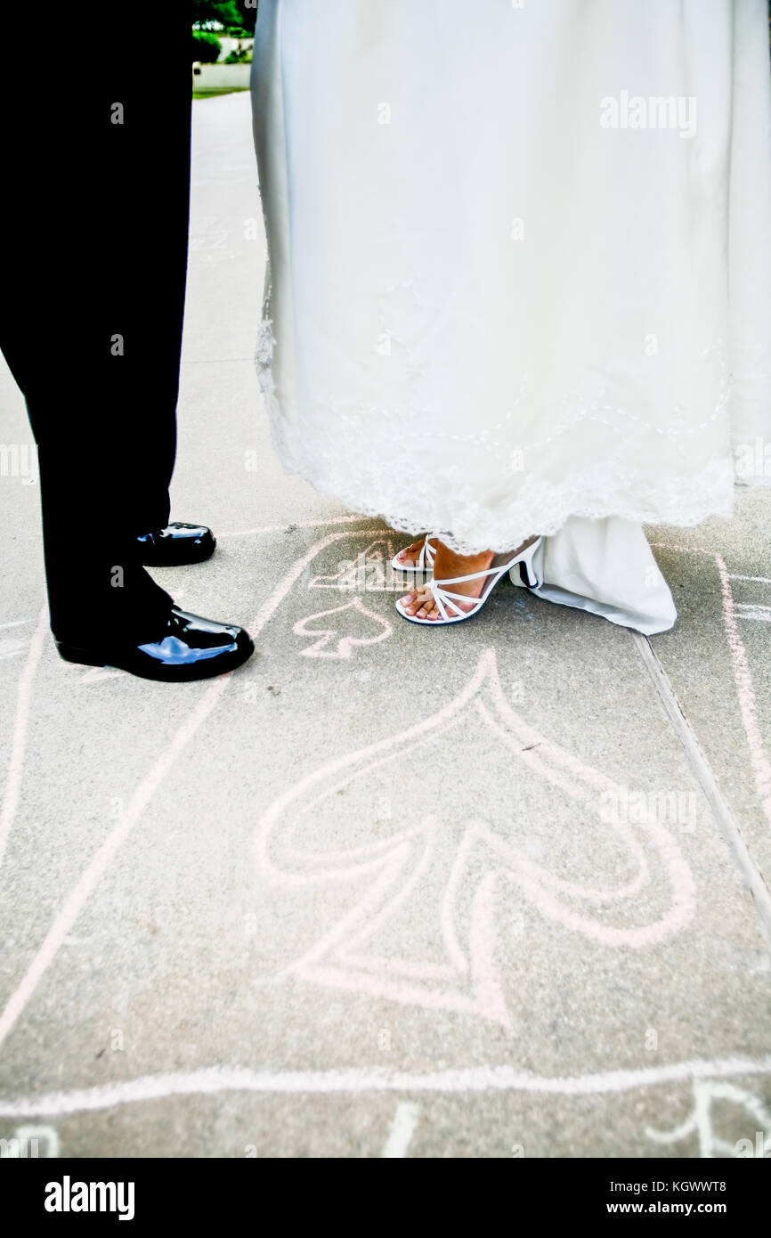 Corpi inferiori vista della sposa e lo sposo in piedi su un chalk cuore disegno su strada Foto Stock