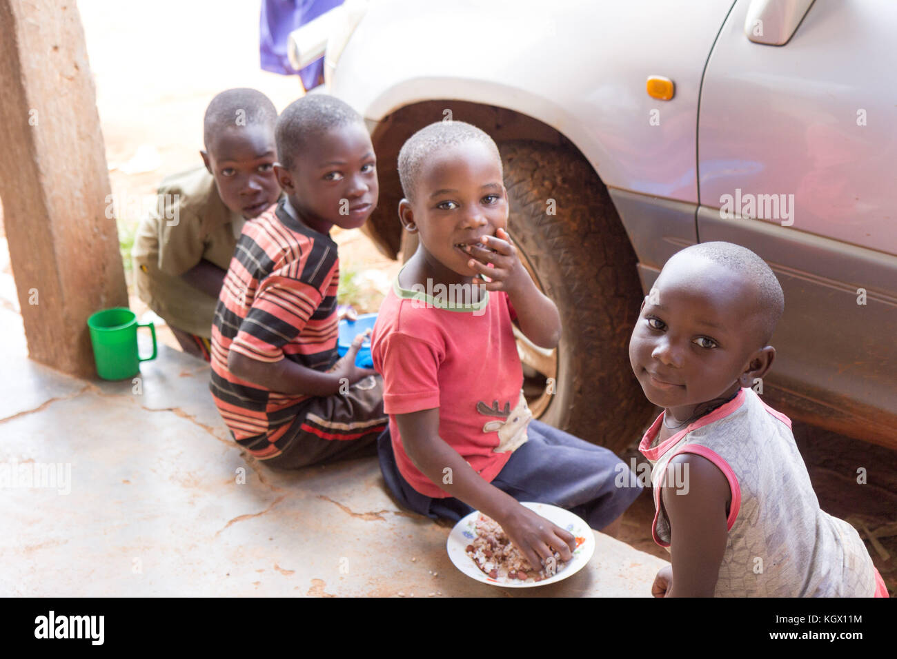 Sorridente bambini seduti e mangiare il porridge. Foto Stock