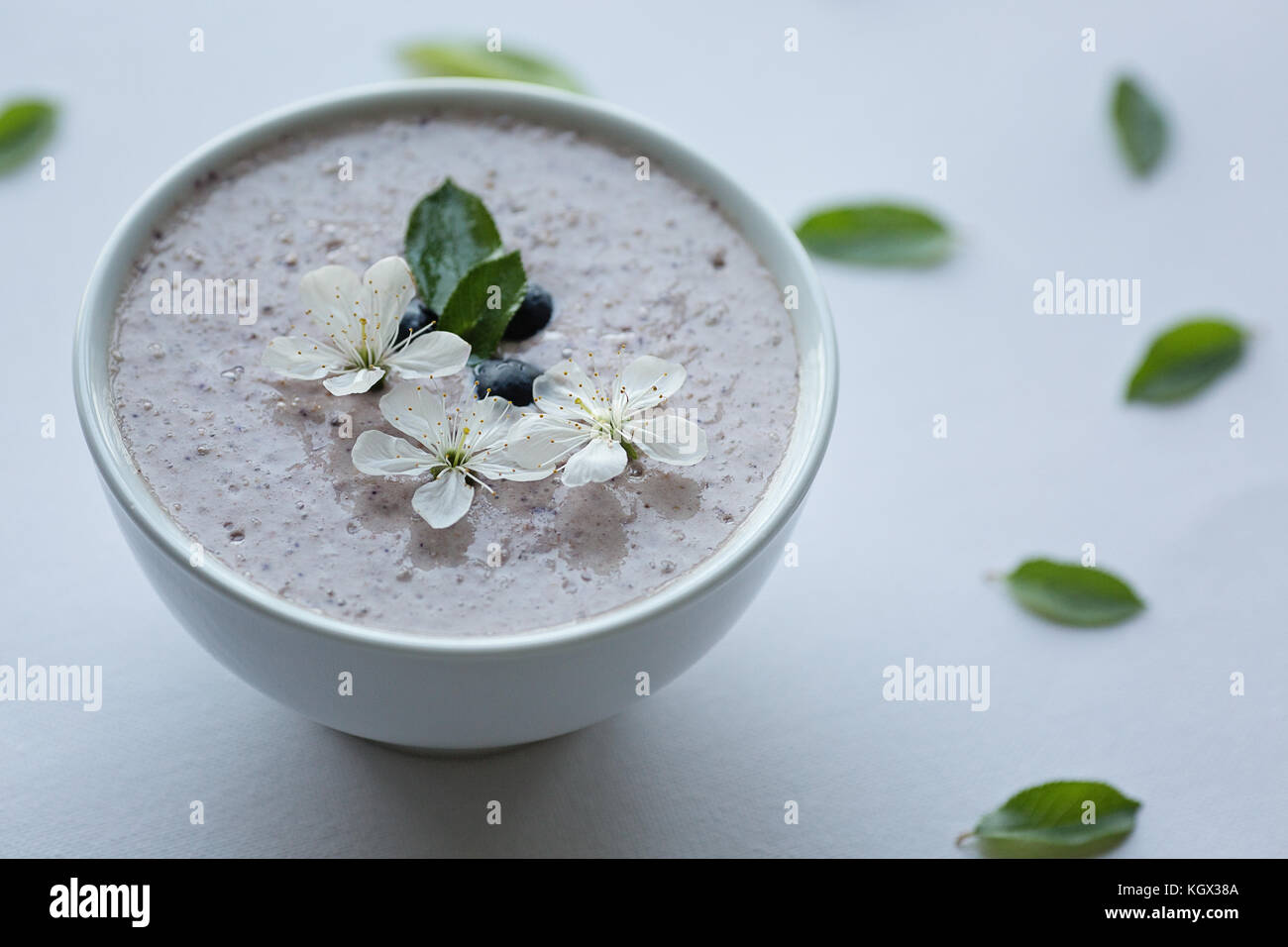 Farina di avena porridge realizzato di avena, purea di banana, latte di mandorla e frutti di bosco, tutti mescolati insieme, isolato su sfondo bianco Foto Stock