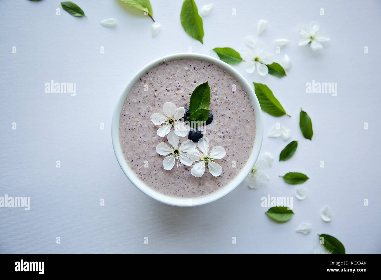 Farina di avena porridge realizzato di avena, purea di banana, latte di mandorla e frutti di bosco, tutti mescolati insieme, isolato su sfondo bianco Foto Stock