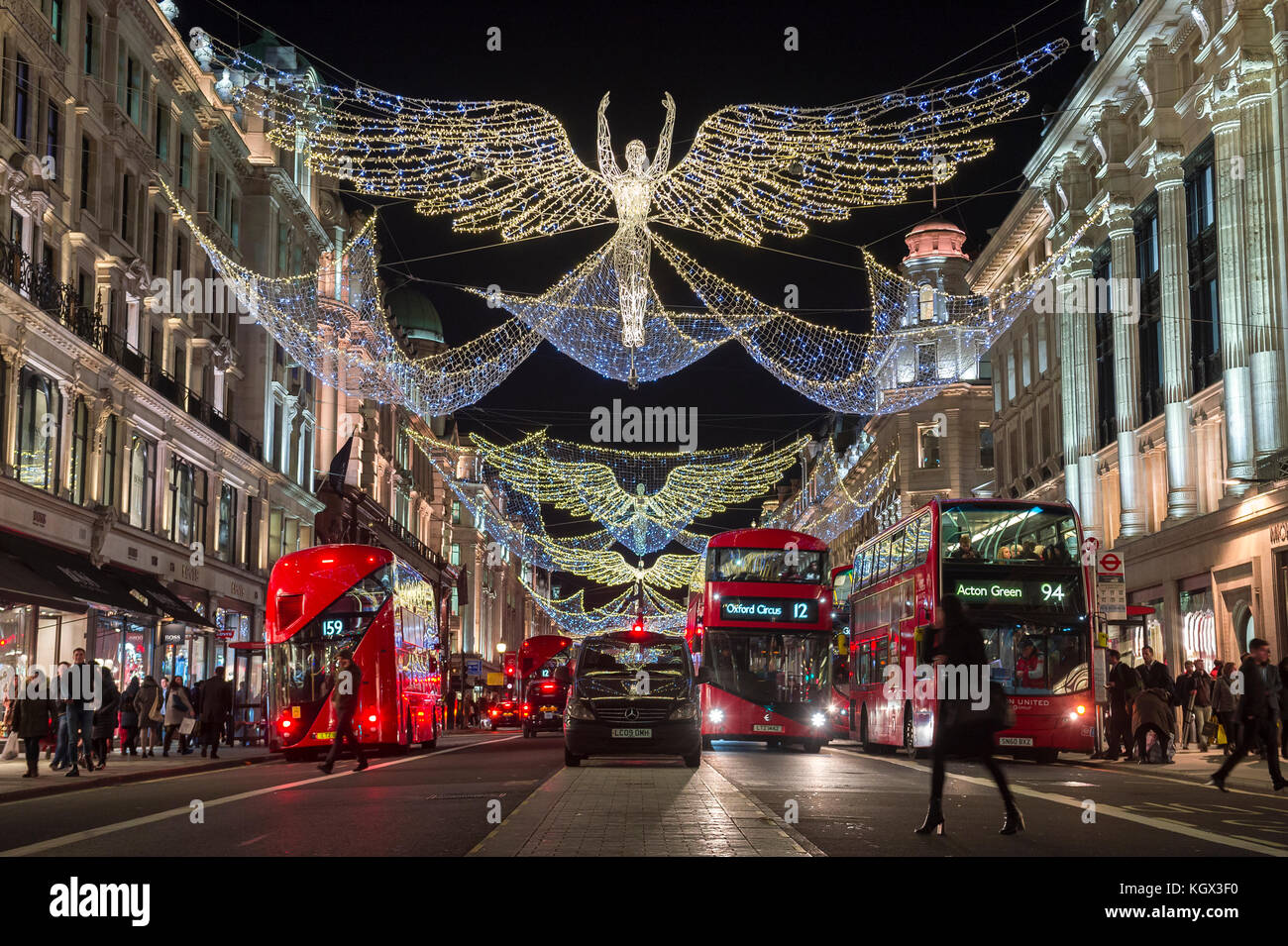 Londra - 18 novembre 2016: autobus rossi a due piani passano sotto scintillanti angeli di natale illuminazione il raffinato quartiere dello shopping di Regent street. Foto Stock