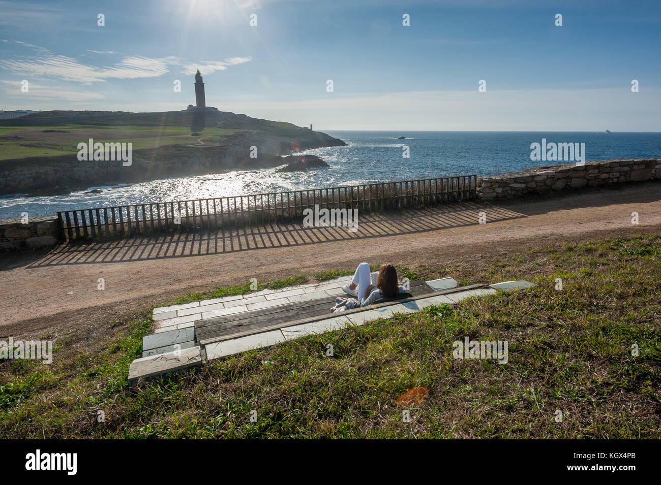 Lettura su un banco dal mare Foto Stock