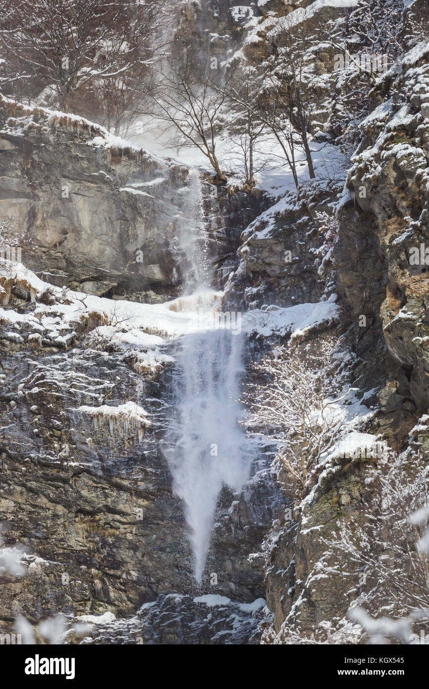 Neve naturale scorrere a valanga a parete di roccia cliff, inverno, alberi Foto Stock