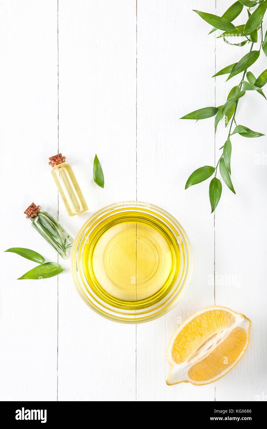 Olio di limone isolato su bianco tavolo in legno Foto Stock