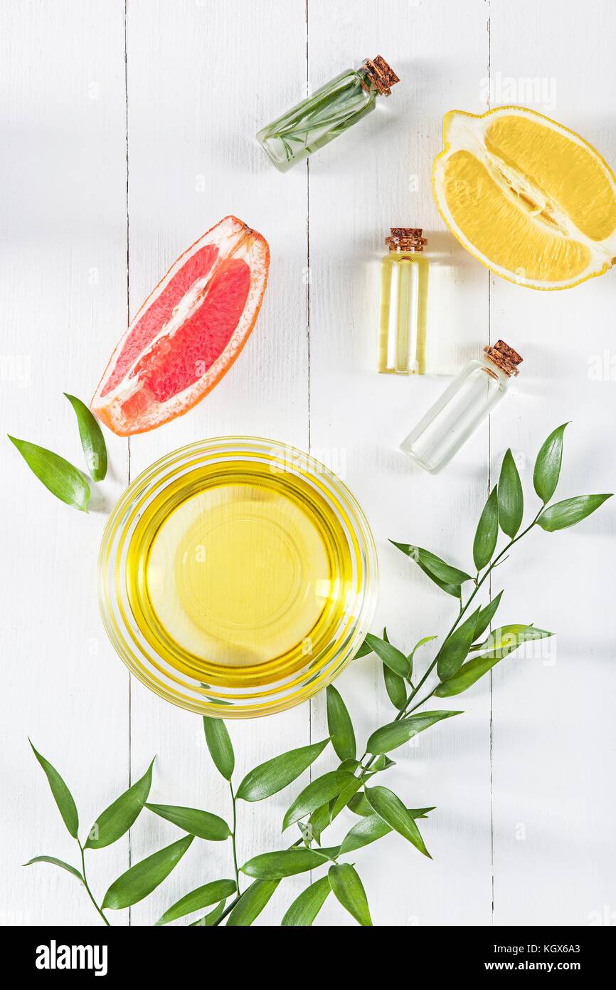 Olio di limone isolato su bianco tavolo in legno Foto Stock