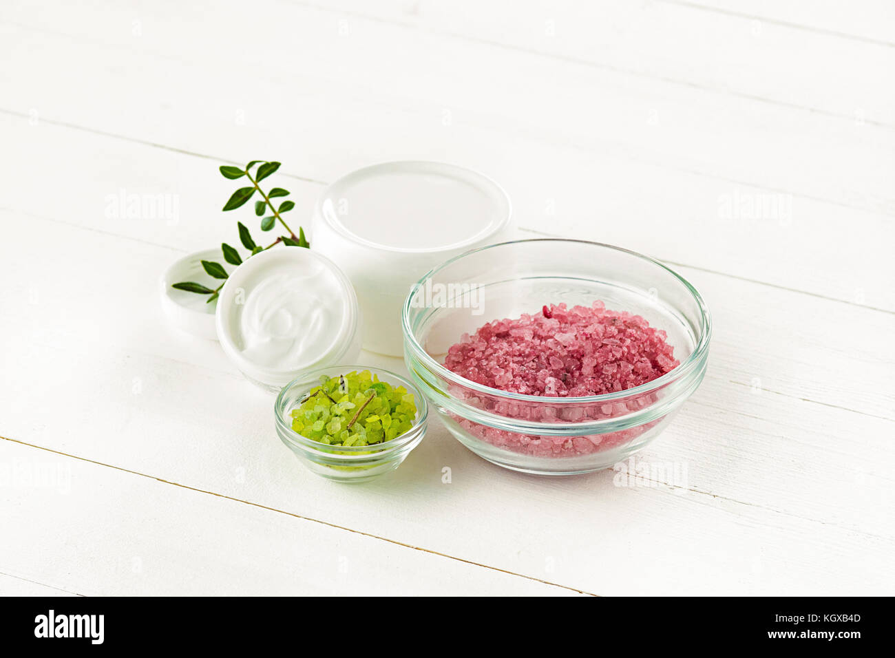 Concetto di spa con sale, menta, lozione, asciugamani su sfondo bianco Foto Stock