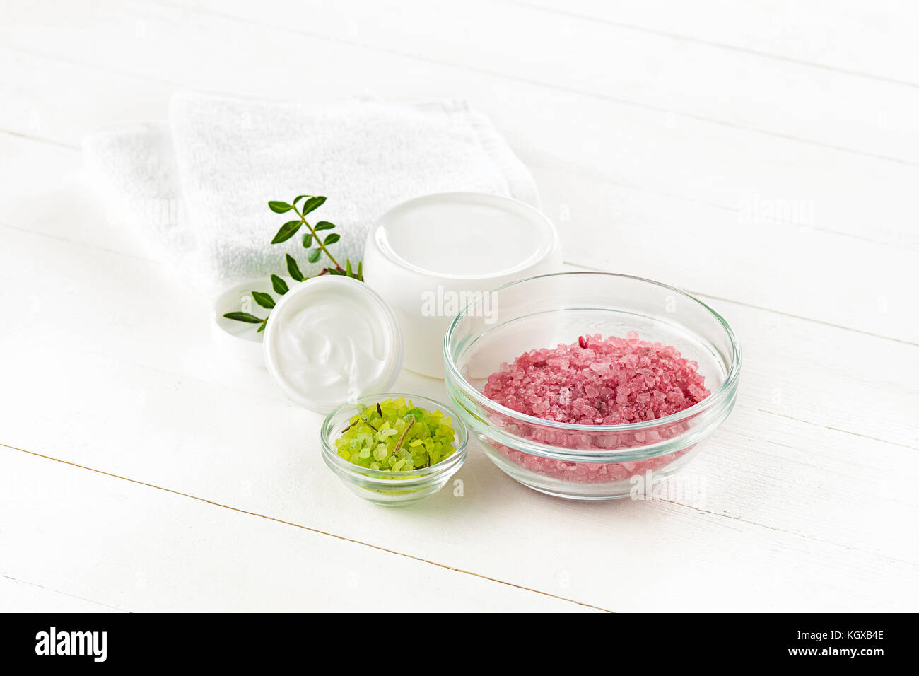 Concetto di spa con sale, menta, lozione, asciugamani su sfondo bianco Foto Stock