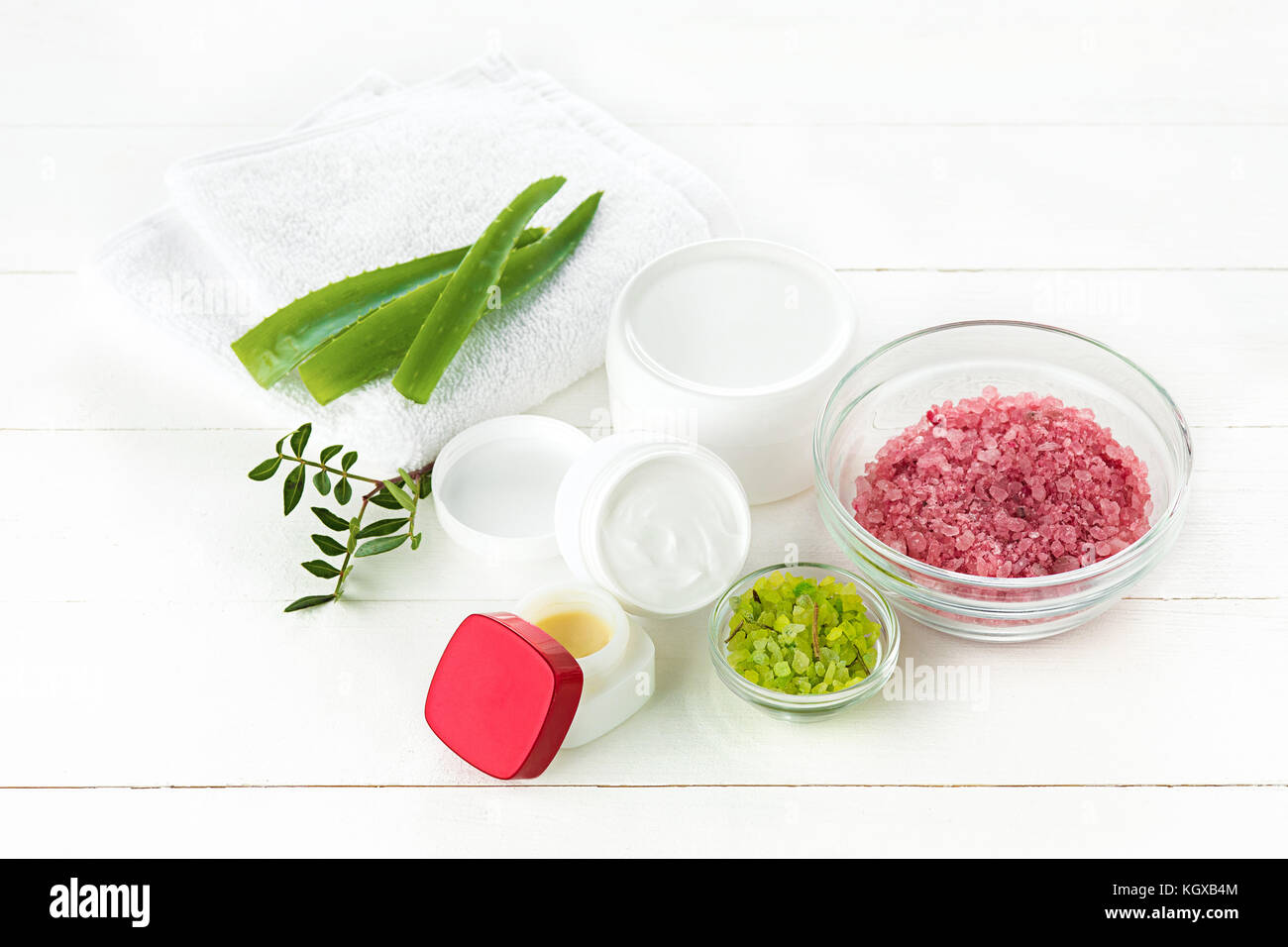 Concetto di spa con sale, menta, lozione, asciugamani su sfondo bianco Foto Stock