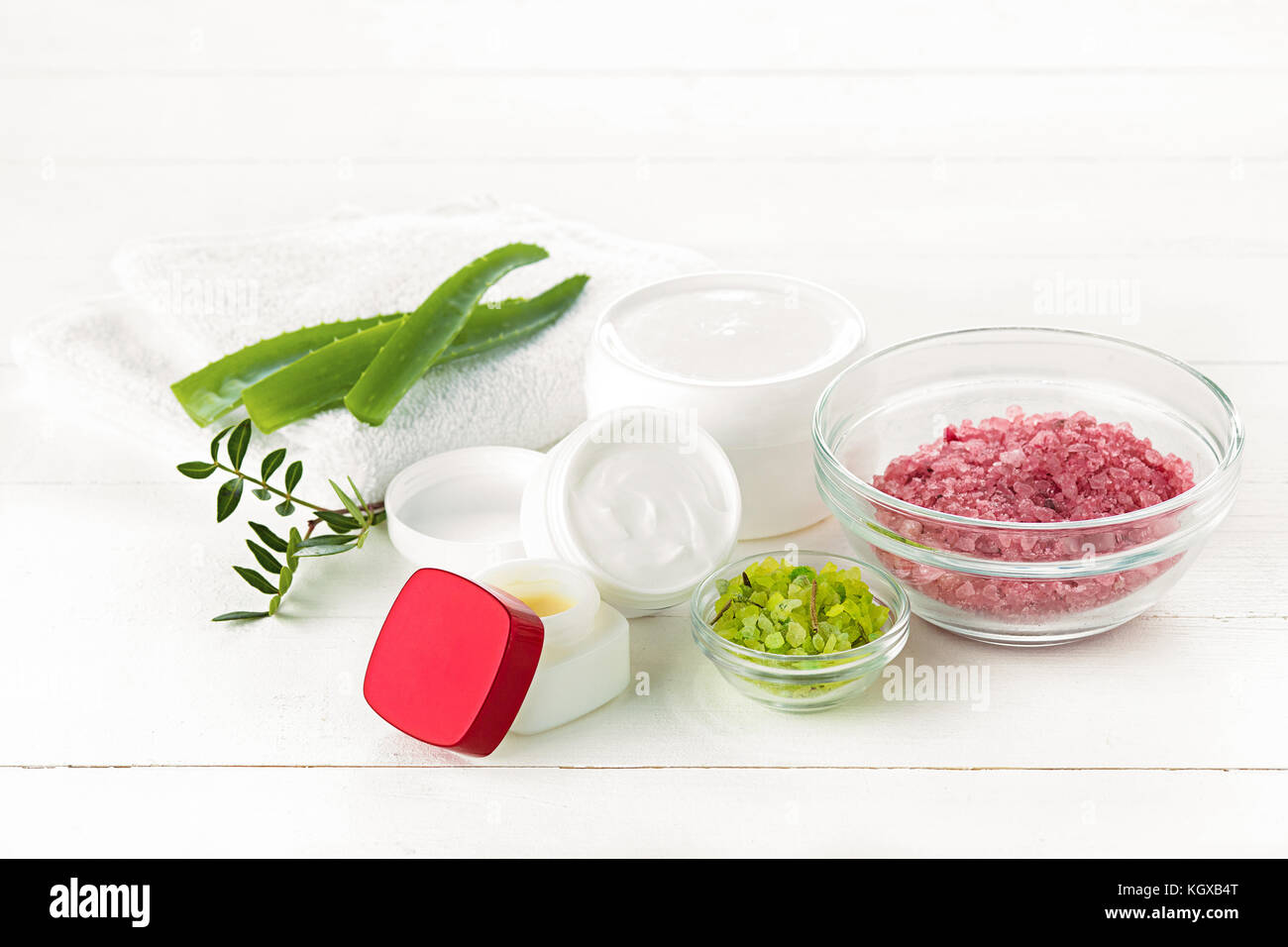 Concetto di spa con sale, menta, lozione, asciugamani su sfondo bianco Foto Stock