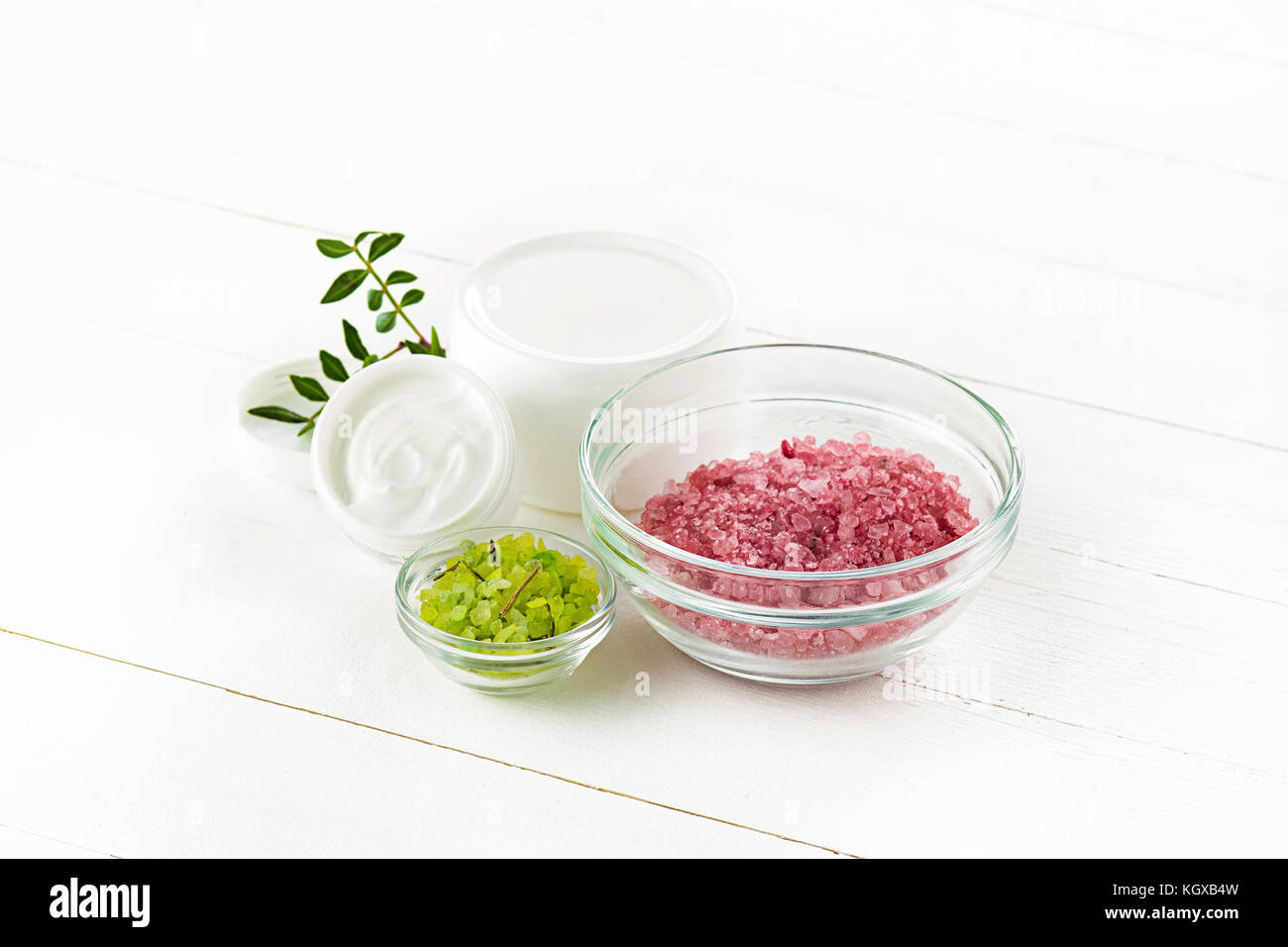 Concetto di spa con sale, menta, lozione, asciugamani su sfondo bianco Foto Stock