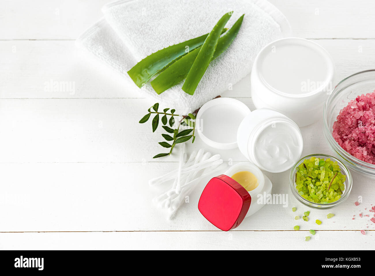 Concetto di spa con sale, menta, lozione, asciugamani su sfondo bianco Foto Stock