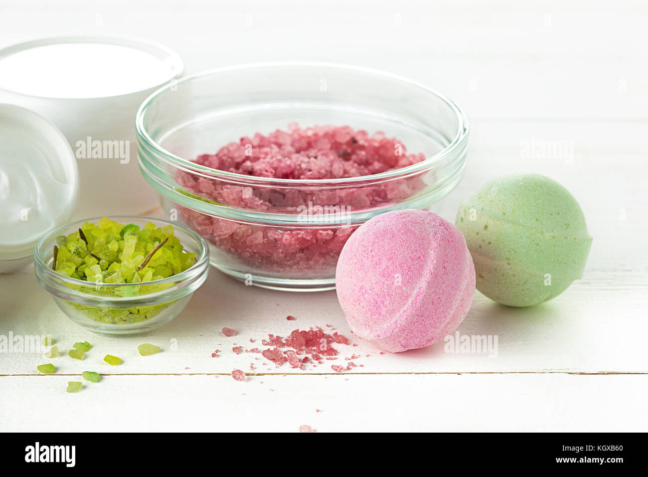 Concetto di spa con sale, menta, lozione, asciugamani su sfondo bianco Foto Stock