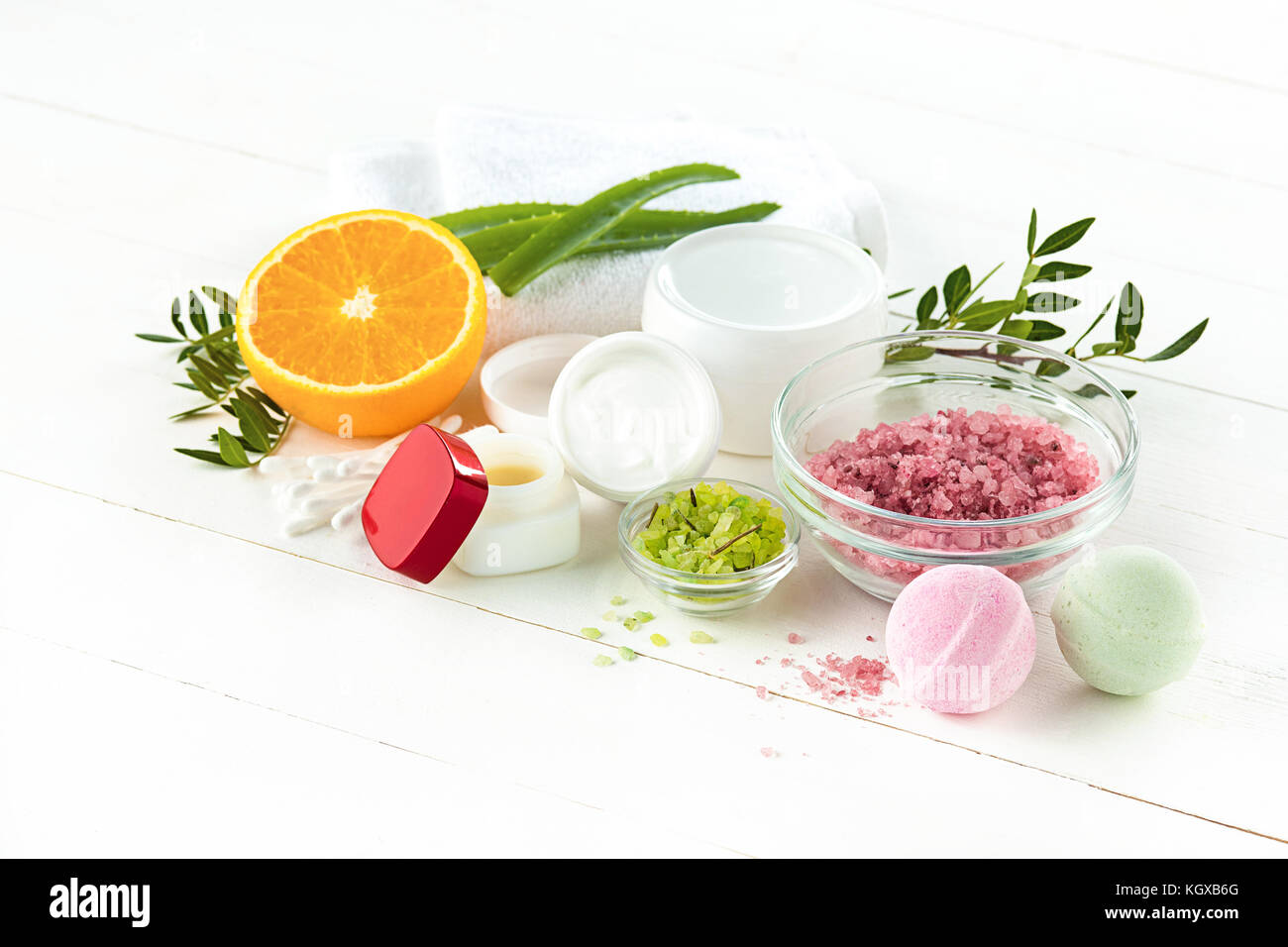 Concetto di spa con sale, menta, lozione, asciugamani su sfondo bianco Foto Stock