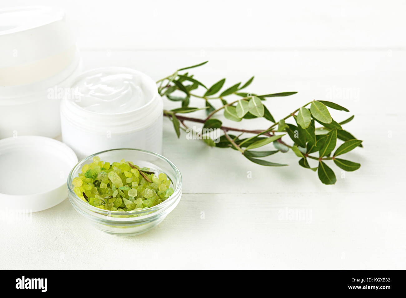 Concetto di spa con sale, menta, lozione, asciugamani su sfondo bianco Foto Stock