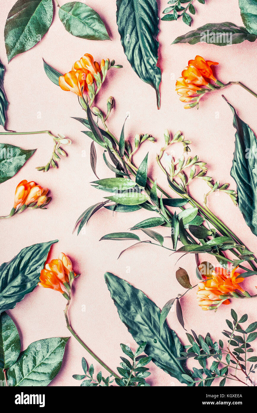 Creative laici piatta fatta di fiori tropicali e foglie di rosa pastello, sfondo vista superiore Foto Stock