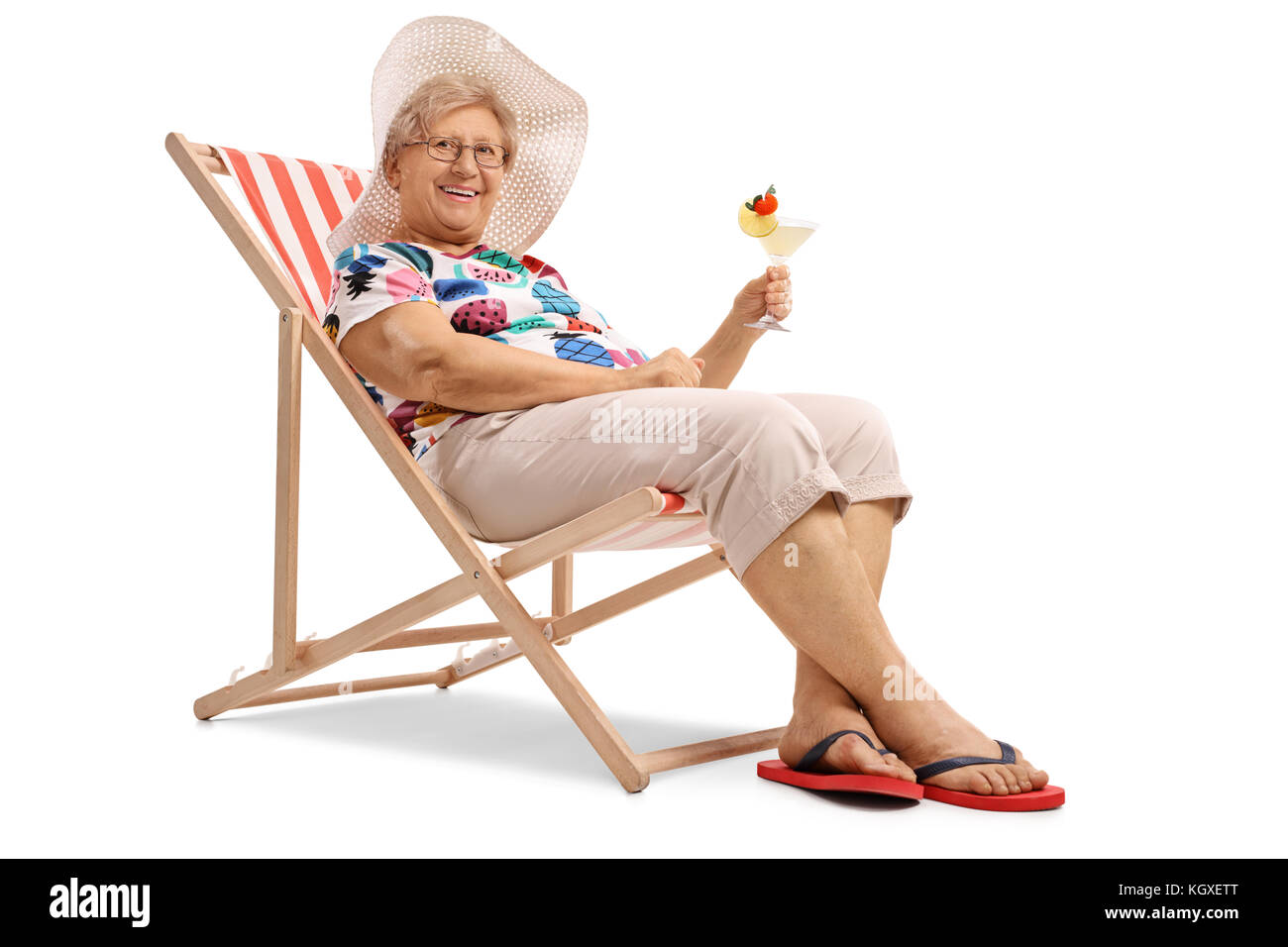 Donna anziana con un cocktail seduti su una sedia a sdraio isolati su sfondo bianco Foto Stock