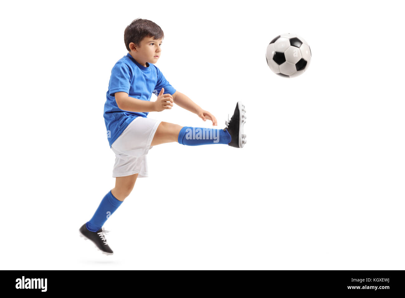 Piccolo giocatore di calcio calci un calcio a mezz aria isolata su sfondo bianco Foto Stock
