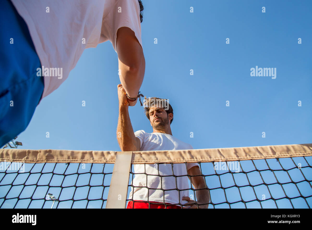 Due tennisti professionisti tenendo le mani sul tennis net prima partita. Foto Stock