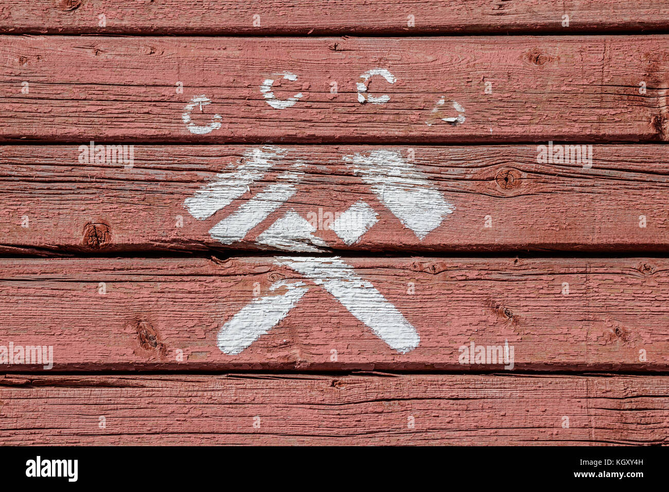 Lettere cccp (russo in forma abbreviata per l'URSS) e un martello incrociati e Monkey Wrench, un simbolo comunista, dipinta in bianco su rosso, weathered, superficie in legno Foto Stock