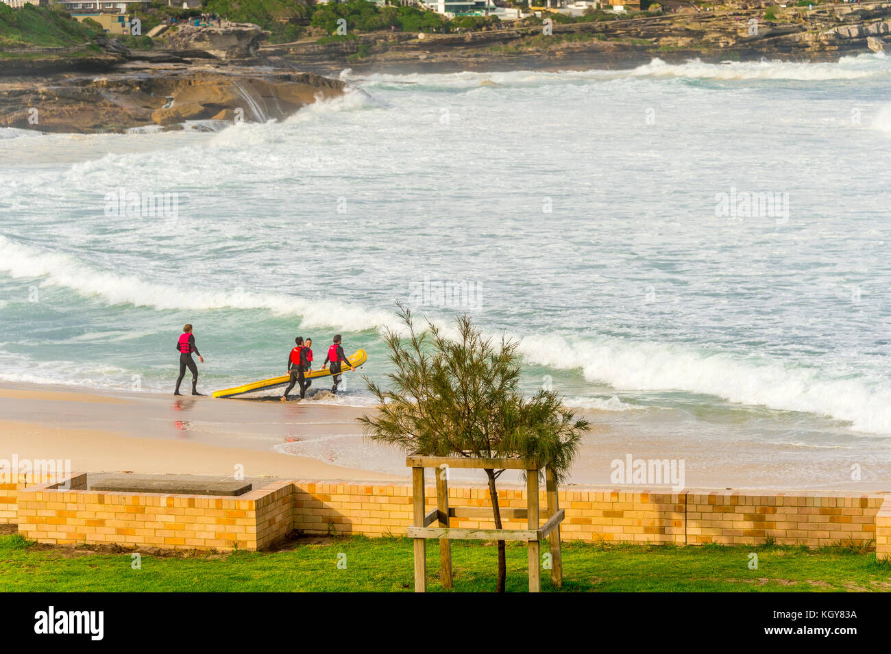 La gomma ducky equipaggio capi in wild condizioni surf a Bronte Beach a Sydney, NSW, Australia Foto Stock