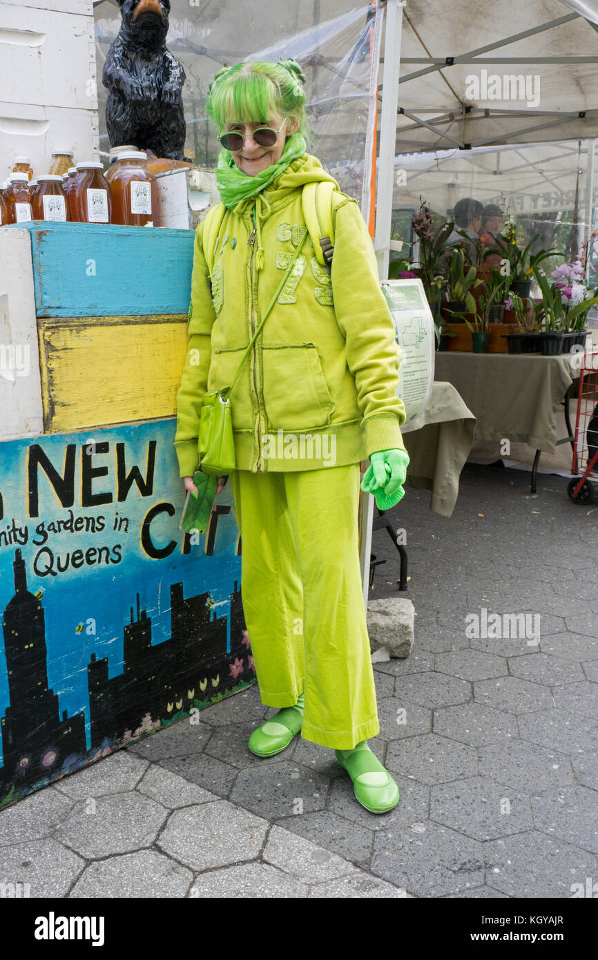 Ritratto di una donna vestito interamente in verde lime. A lui la Union Square Mercato verde a Manhattan, New York City. Foto Stock