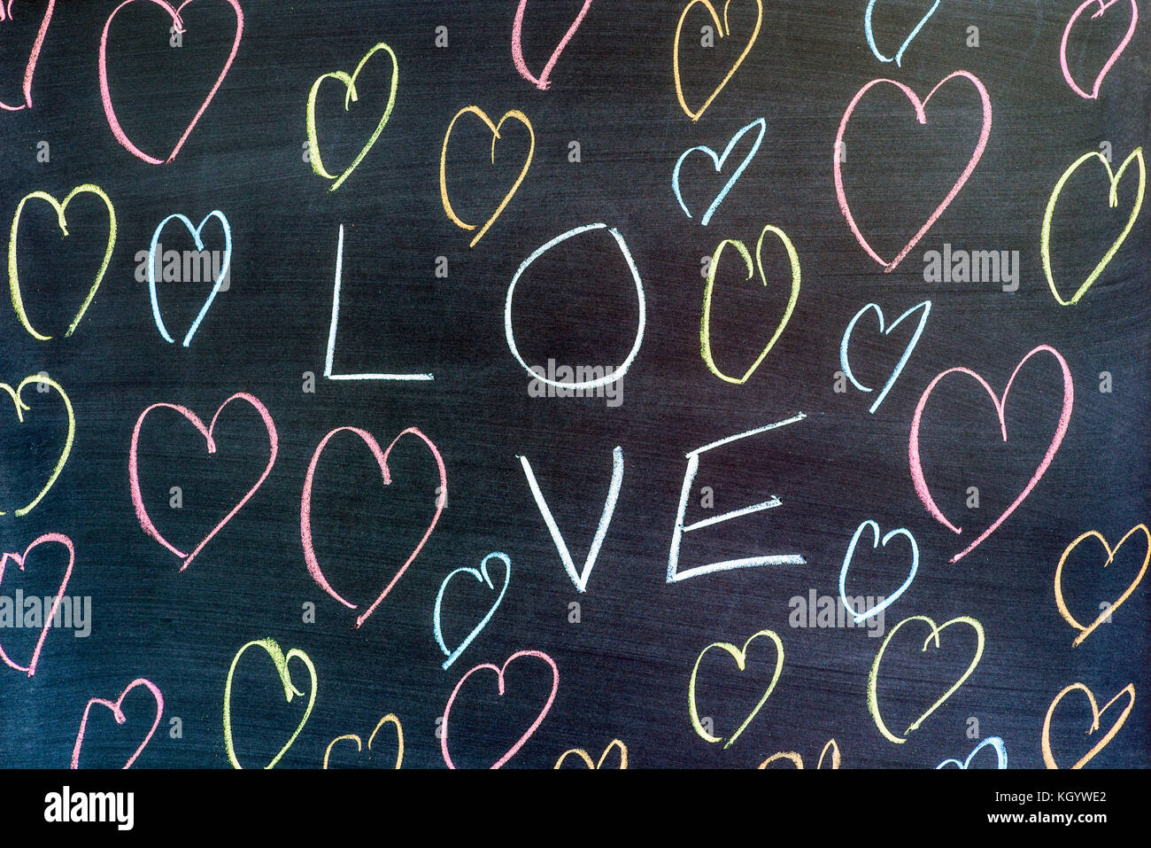 La parola amore e forme di cuore scuro su sfondo colorato. Foto Stock