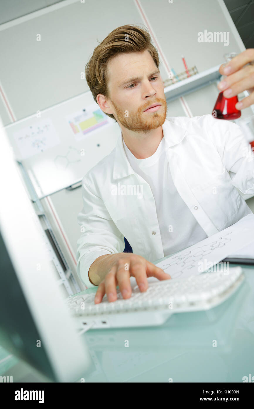 Lavoratore di laboratorio guardando al prodotto e accigliata Foto Stock