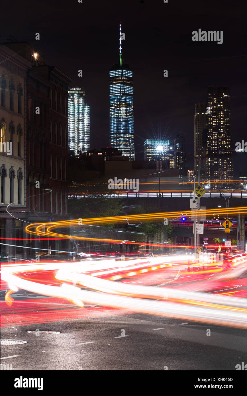 Luci del veicolo una lunga esposizione su occupato Brooklyn Bridge Road con One World Trade Center e grattacieli di Manhattan in background, New York, Stati Uniti d'America Foto Stock