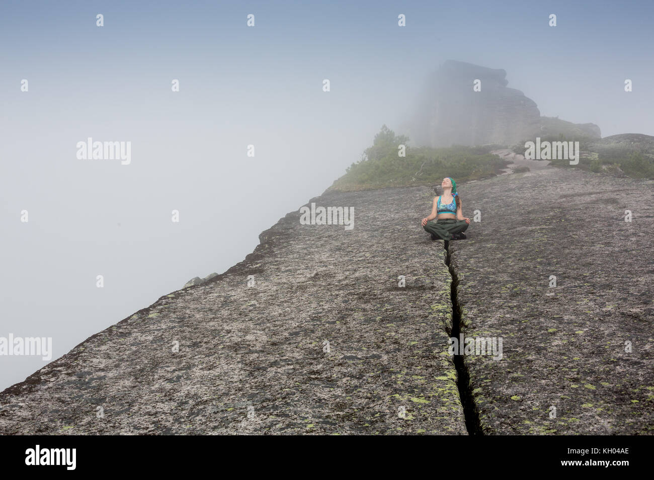 Donna in piedi sulla solida roccia per evitare terremoto Foto Stock