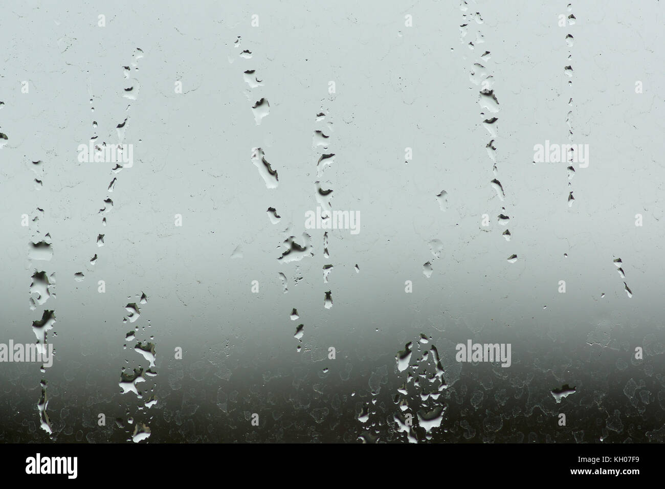 Le goccioline di acqua e flussi di acqua sul vetro Foto Stock