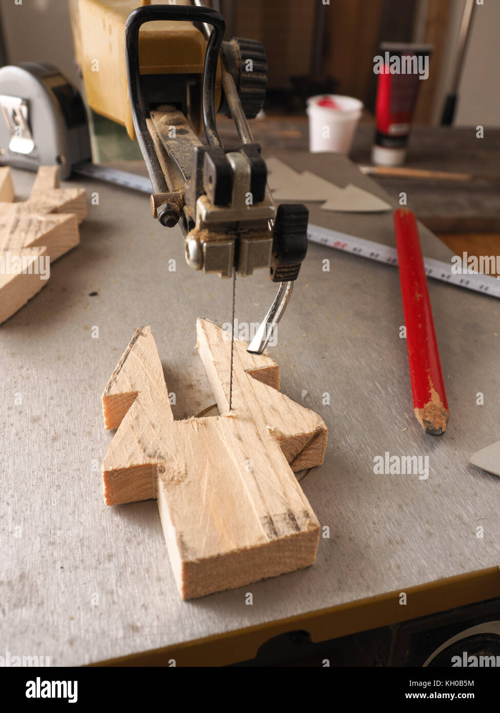 Lavorazione del legno concetto con una sega di scorrimento, rendendo un di legno Decorazione per albero di Natale Foto Stock