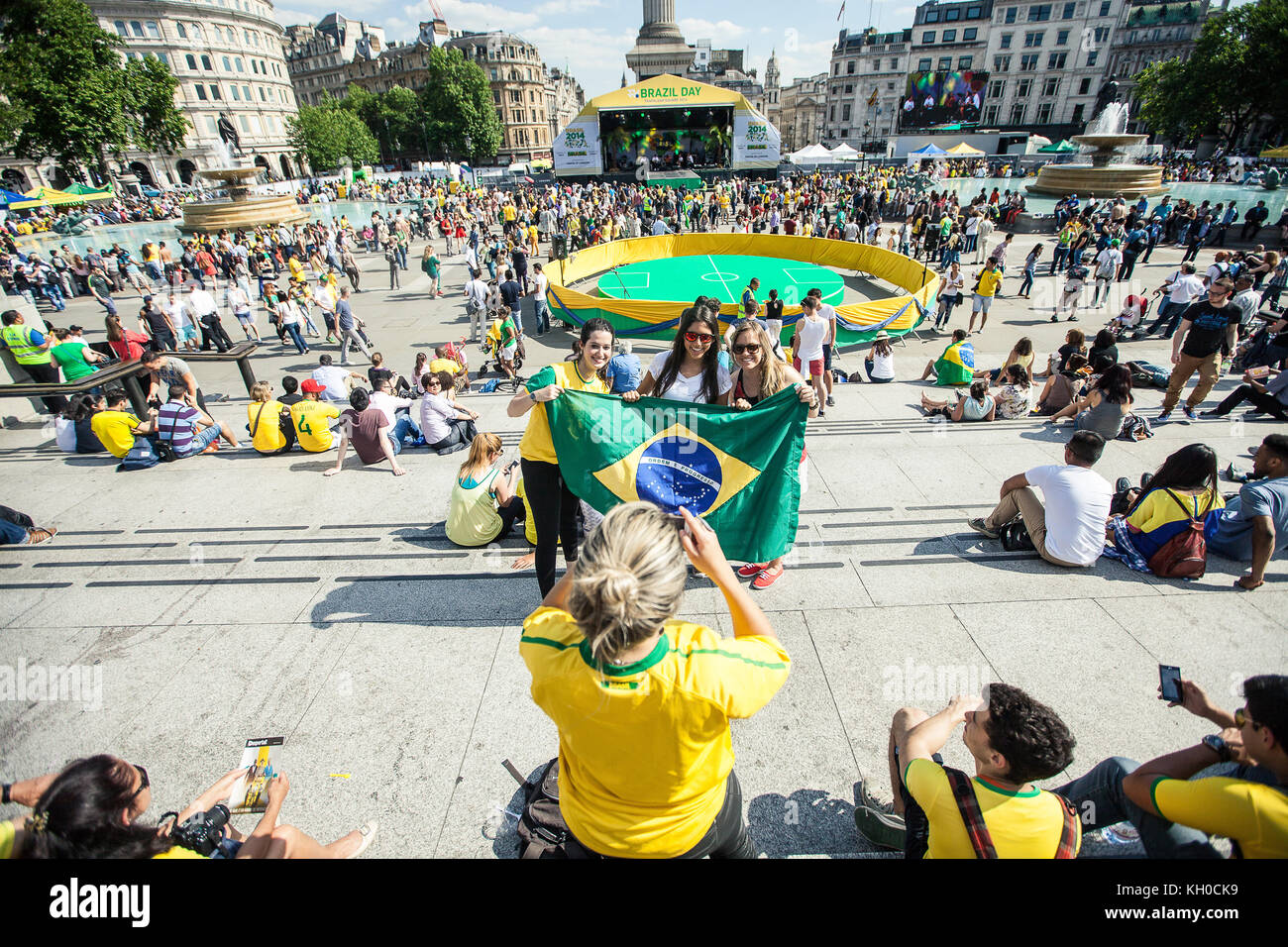 Tre donne in Brasile in kit per una foto di gruppo con la bandiera del Brasile. Sono pronti per l’apertura della Coppa del mondo di stasera tra Brasile e Croazia in occasione della Coppa del mondo FIFA 2014. REGNO UNITO 12/06 2014. Foto Stock