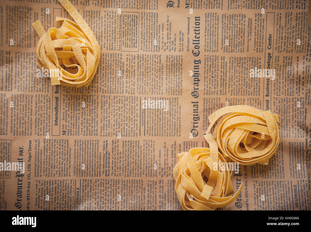 Materie fettuccine su marrone vecchio giornale Foto Stock