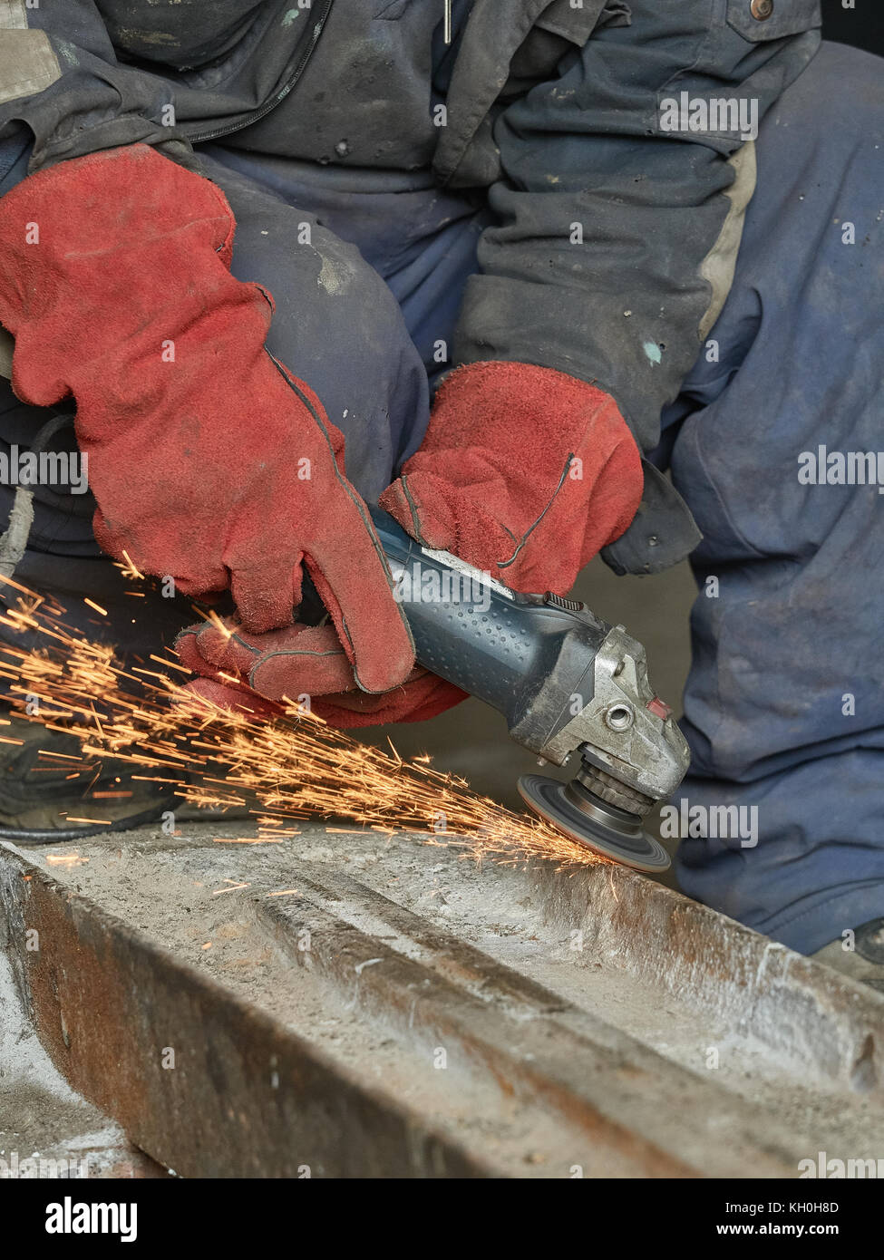 Lavoratore macina una rampa di metallo per la successiva saldatura.La foto mostra le scintille di La Mola. Foto Stock