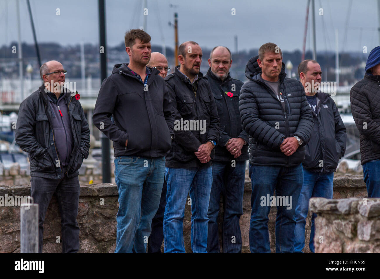 Un gruppo di uomini che indossano papaveri al ricordo, servizio il giorno dell'Armistizio 2017 presso il cenotafio in Torquay, Devon, Regno Unito. Novembre 2017. Foto Stock