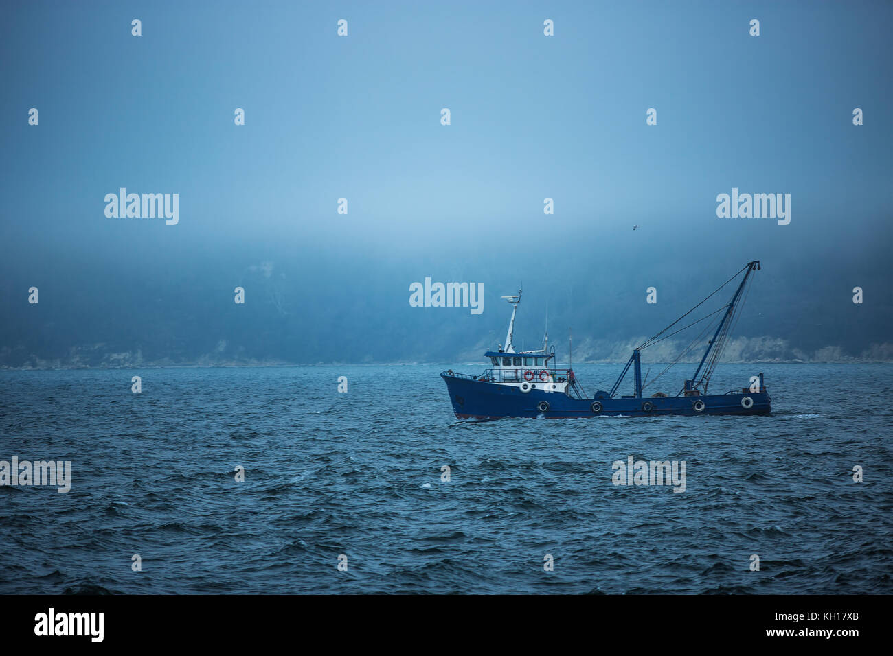 La pesca a strascico in barca a vela in acque aperte in un freddo e nebbioso giorno, sunrise shot Foto Stock