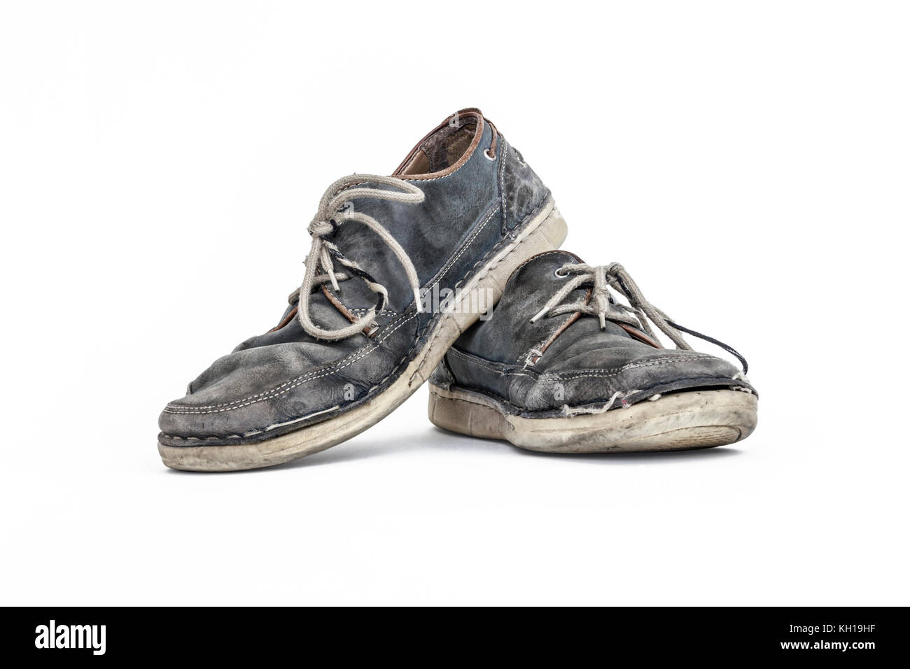 Una coppia di vecchi usurato in pelle grigio scarpe con lacci contro uno sfondo bianco Foto Stock