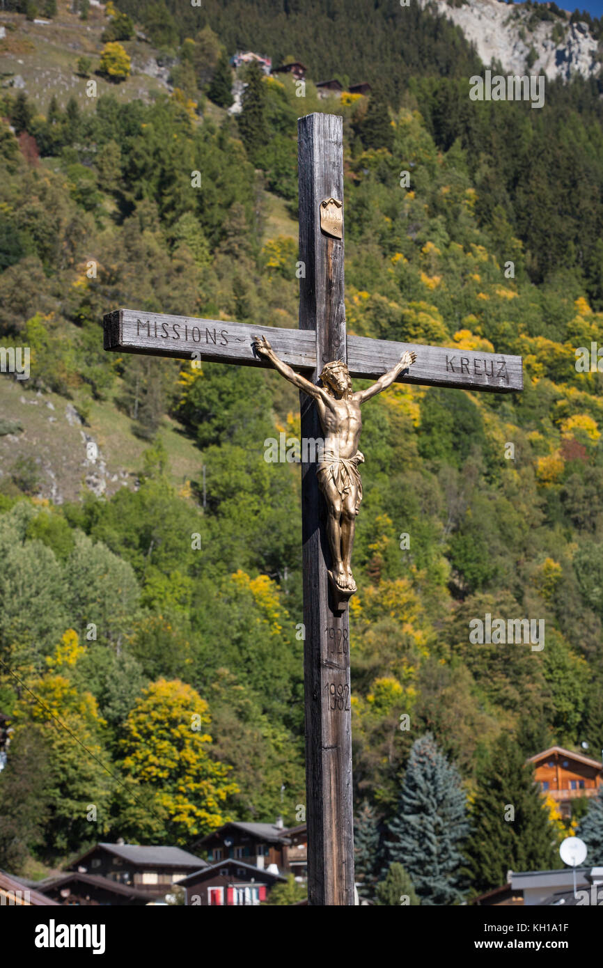 BLATTEN, Svizzera - sept. 25, 2017 - Una vecchia croce cristiana con un bronzo Gesù appeso davanti a una frest con inizio autunno colori. Foto Stock