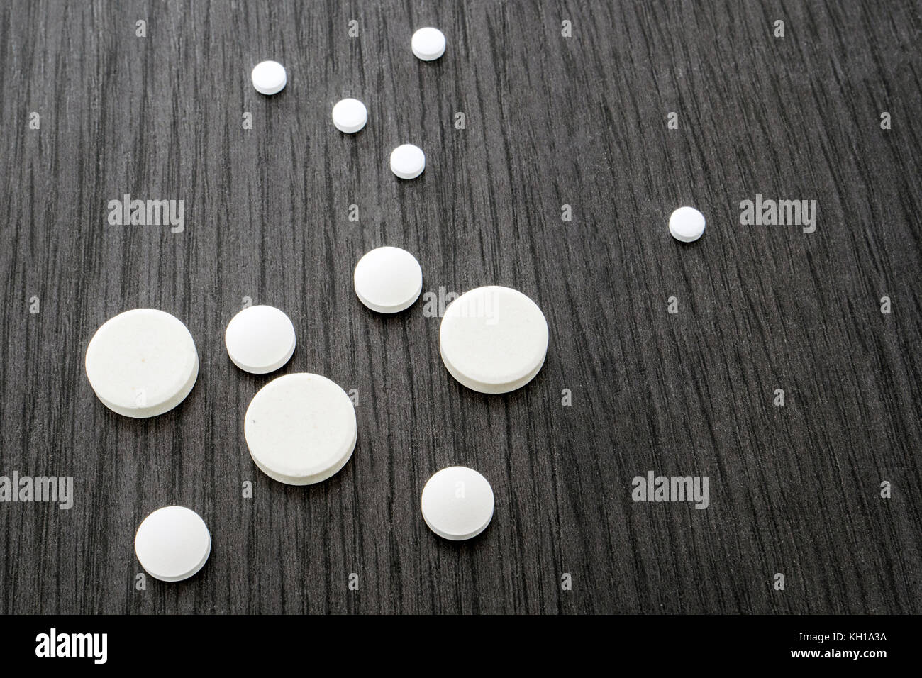 Alcuni round white pillole di diverse dimensioni Foto Stock