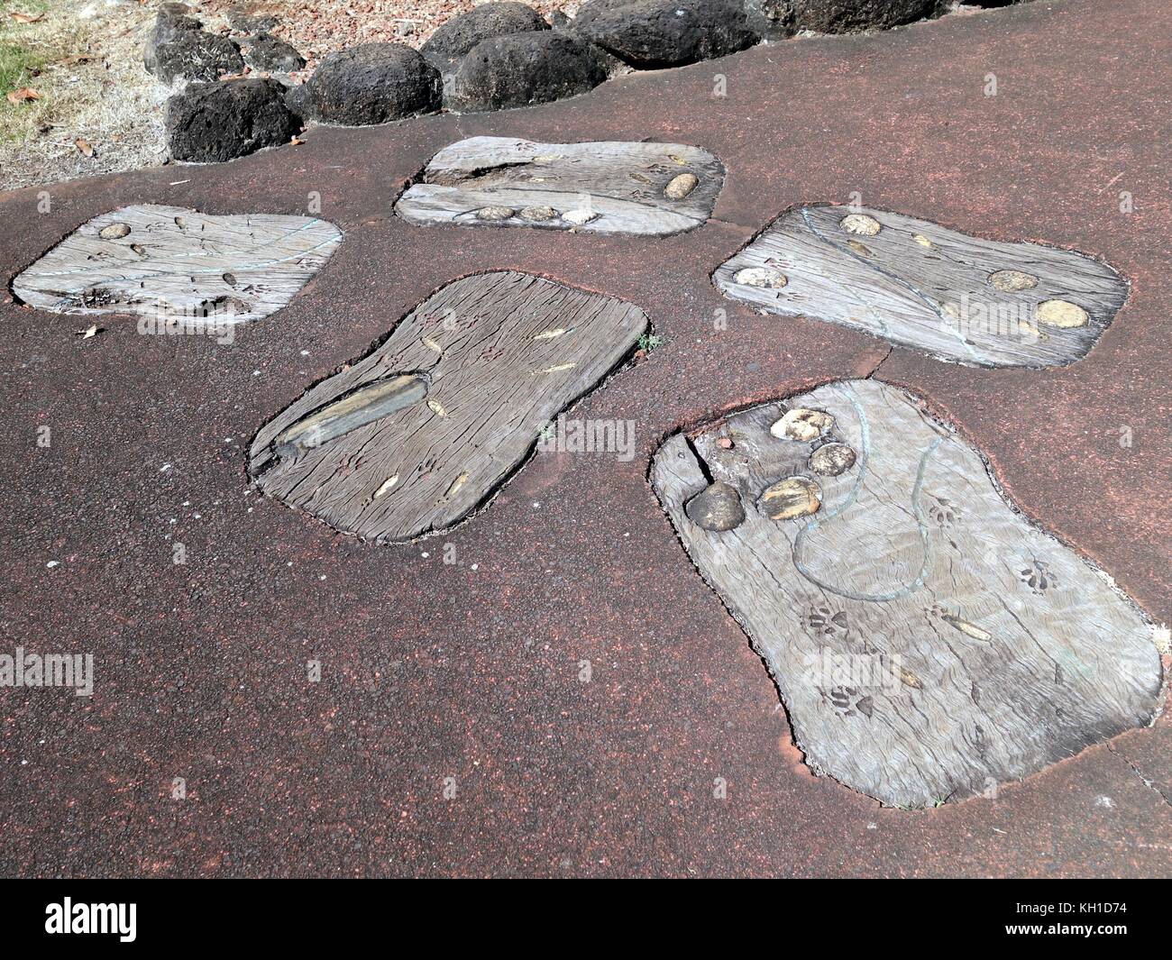 Halloran Hill Environmental Park, Atherton, Queensland, Australia - 24 agosto 2017: Arte aborigena su grandi impronte di legno ambientate in un percorso di cemento Foto Stock