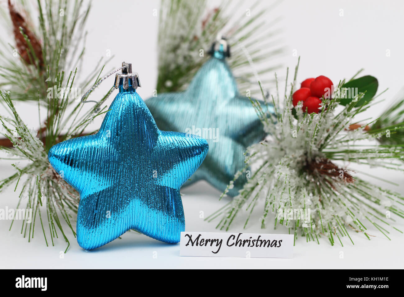 Merry Christmas card con baubles blu a forma di stella con coperta di neve pine Foto Stock