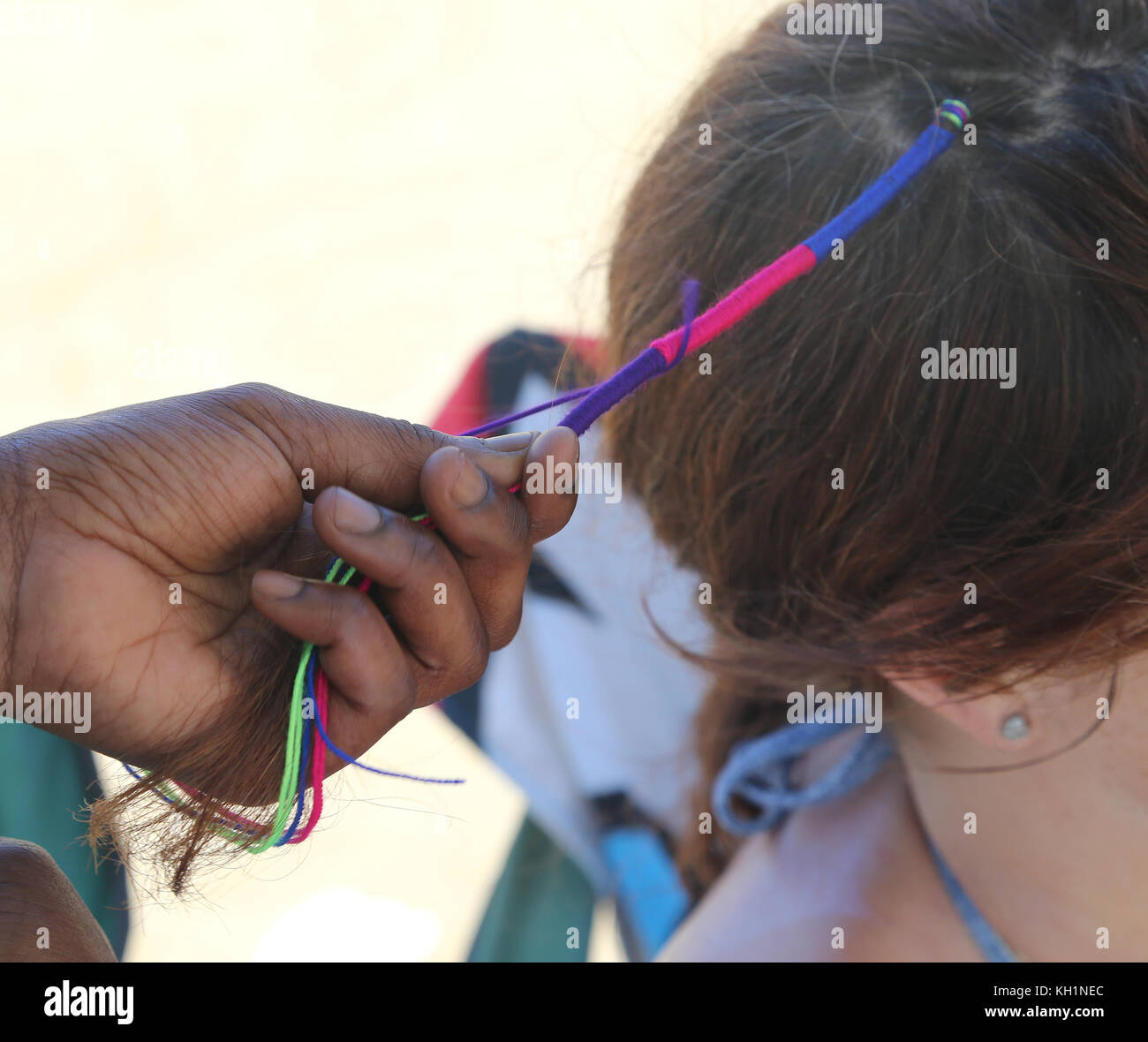 Donna africana mano facendo una pettinatura con una treccia colorata in un  ai capelli della ragazza Foto stock - Alamy