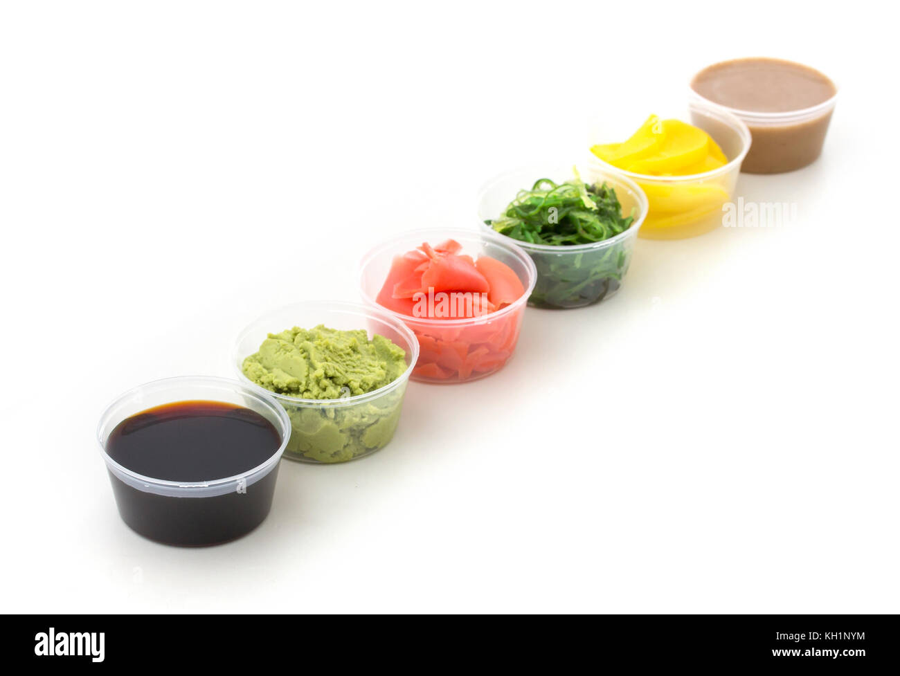 La salsa di soia, wasabi, zenzero sott'aceto, chuka, salsa di sesamo e decapati ravanelli in un piccolo recipiente isolato su sfondo bianco Foto Stock