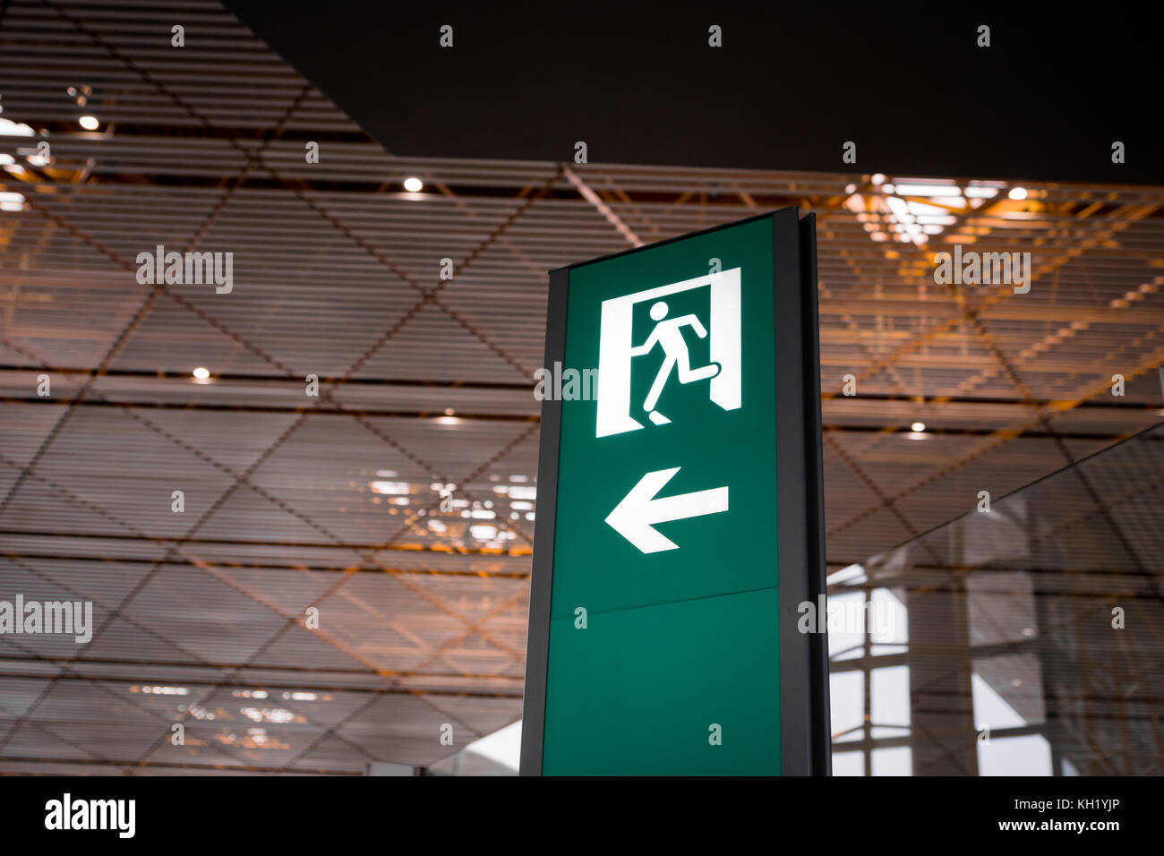 Emergency fire exit segno verde brillante in aeroporto Foto Stock