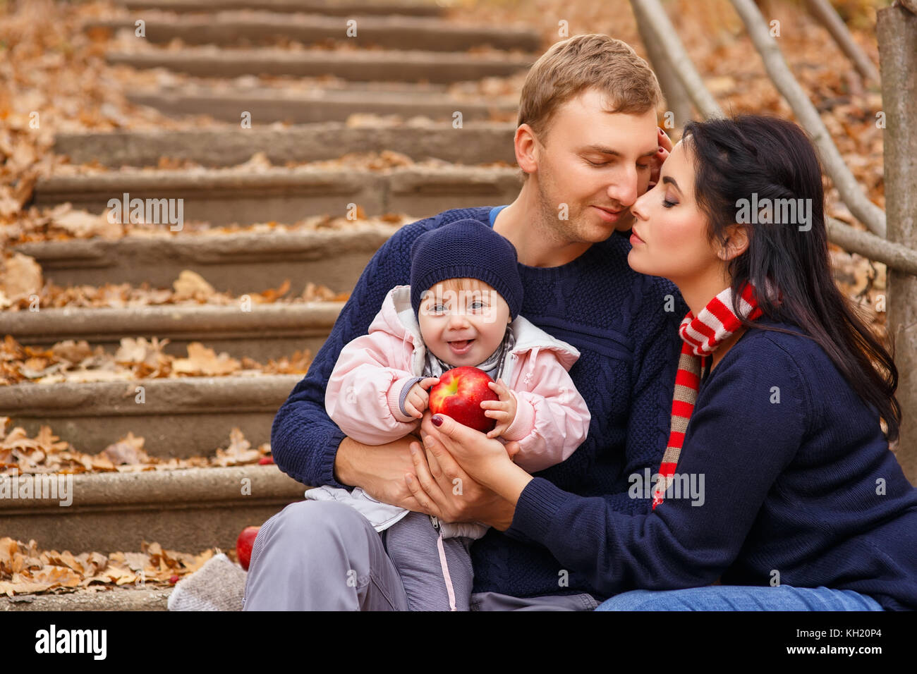 I giovani genitori con la piccola figlia in autunno foresta. mamma e papà holding Baby girl in mani. famiglia felice, amore parentale stagione autunnale concept Foto Stock