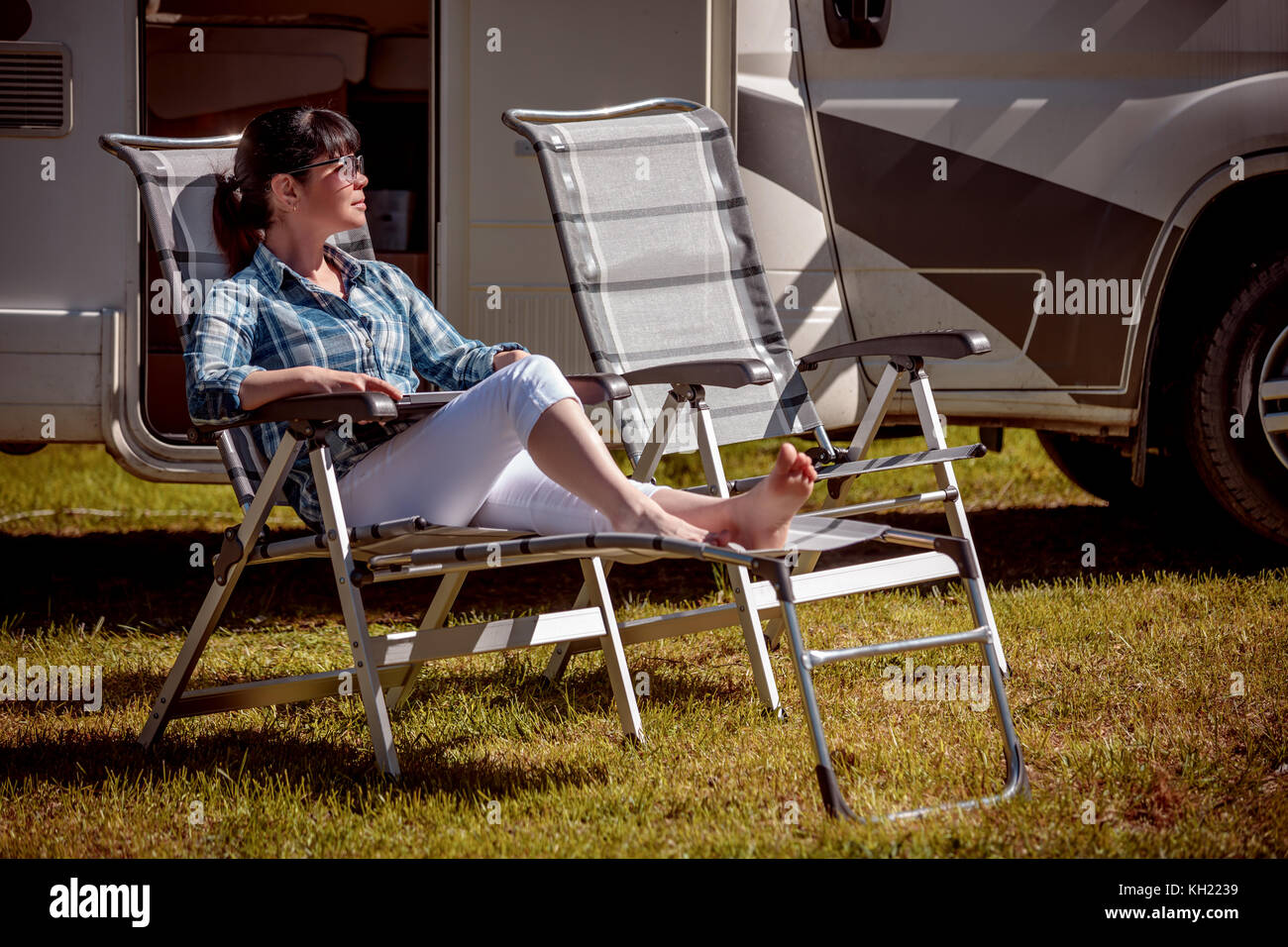 Donna adagiata vicino i camper in natura. vacanza con la famiglia in viaggio, viaggio vacanza in camper rv, caravan auto vacanza. Foto Stock